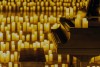 A piano in a church surrounded by candles