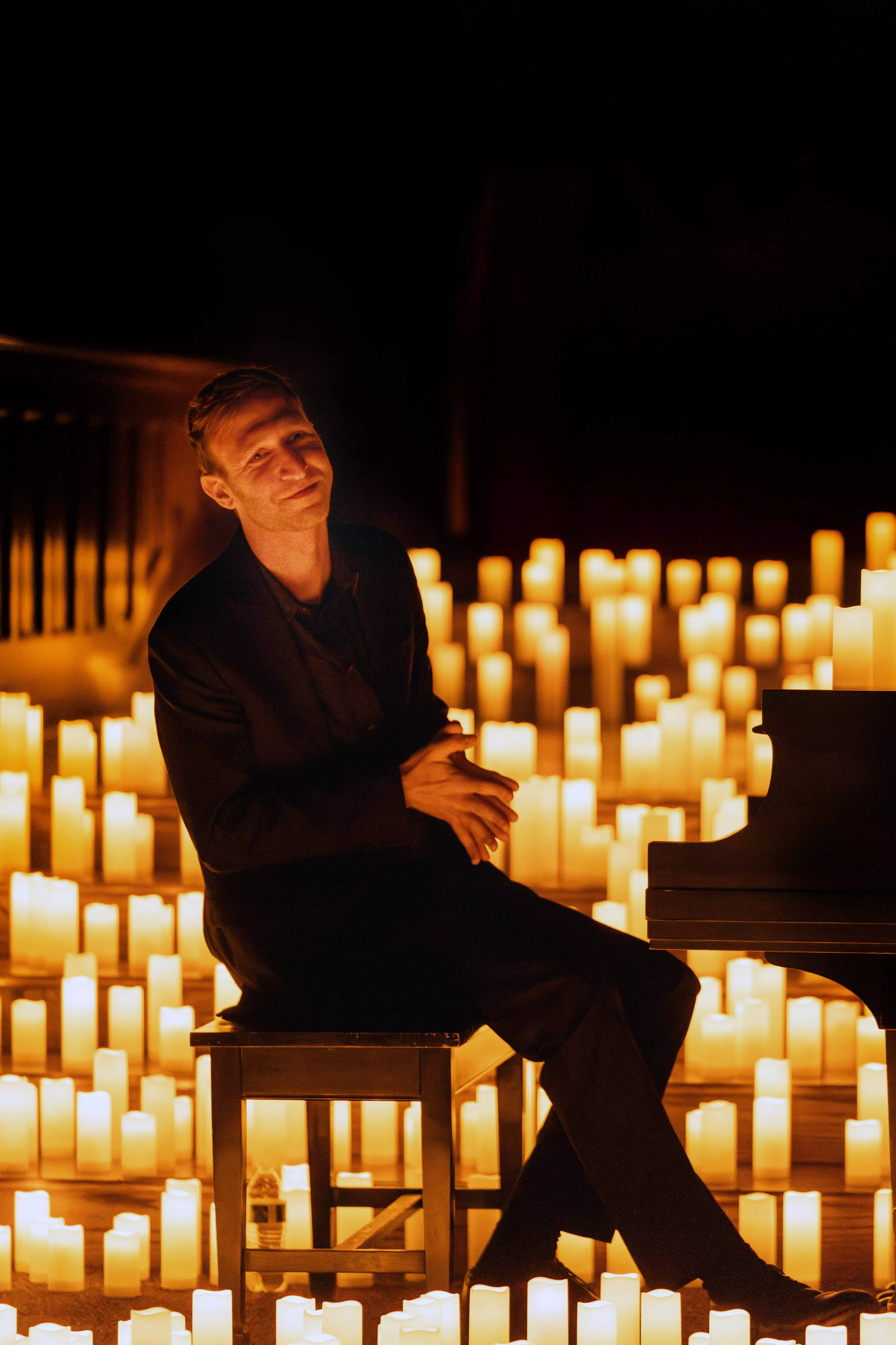 A piano in a church surrounded by candles