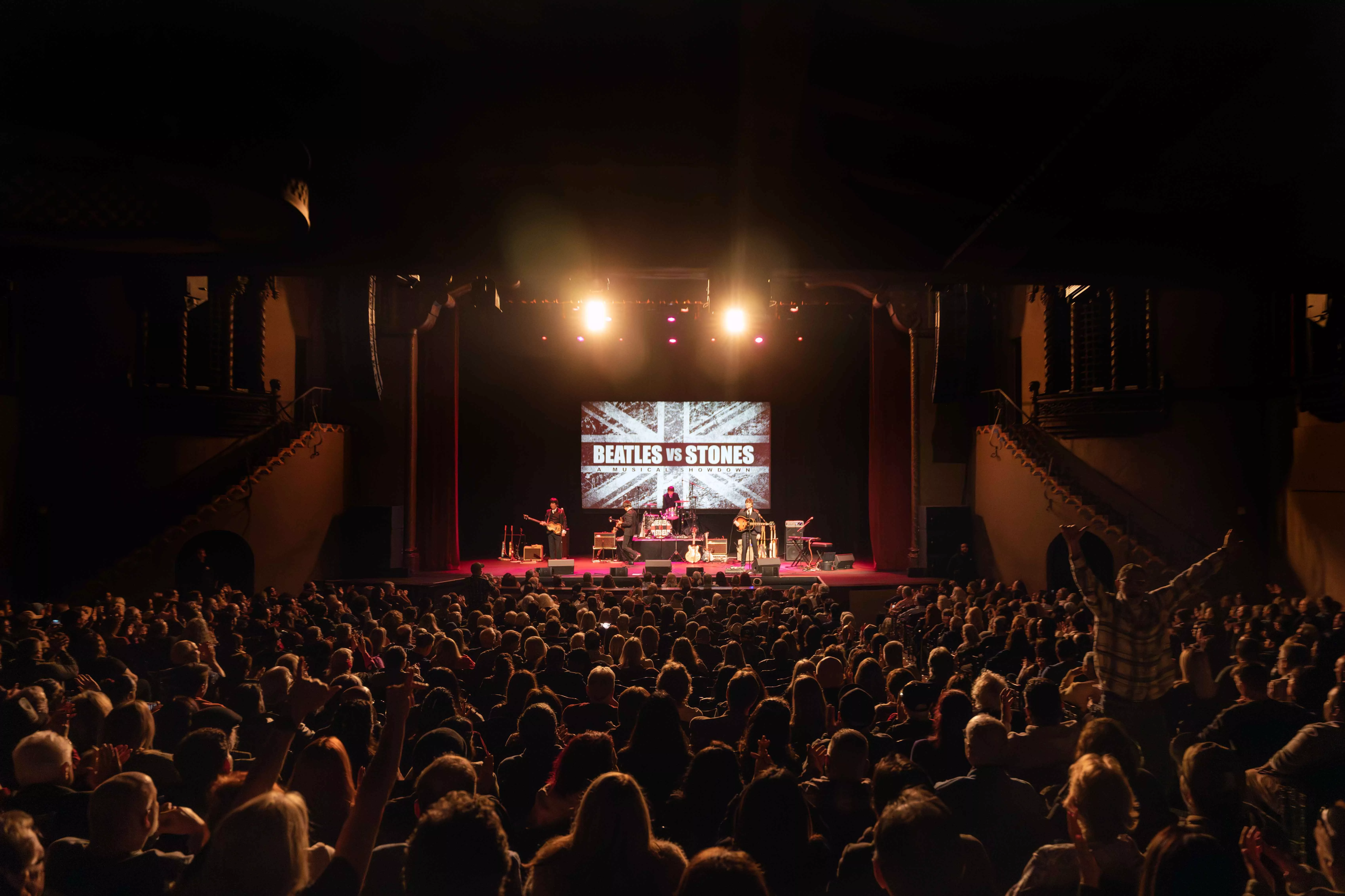 A tribute band impersonating the Beatles plays on the stage at Fox Perfoming Arts Center