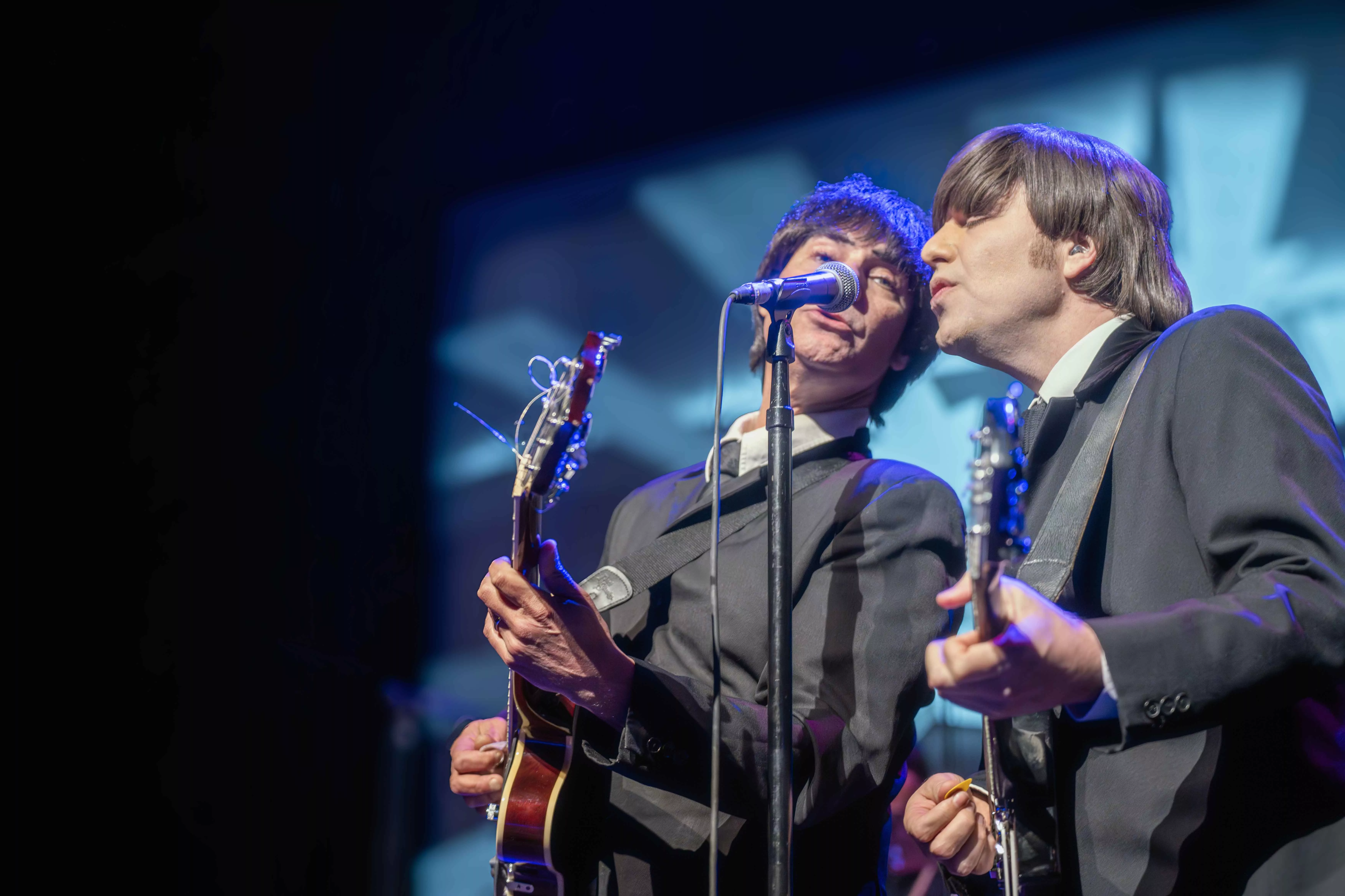 A tribute band impersonating the Beatles plays on the stage at Fox Perfoming Arts Center