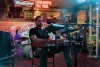 Three members of a band perform at a local restaurant and bar