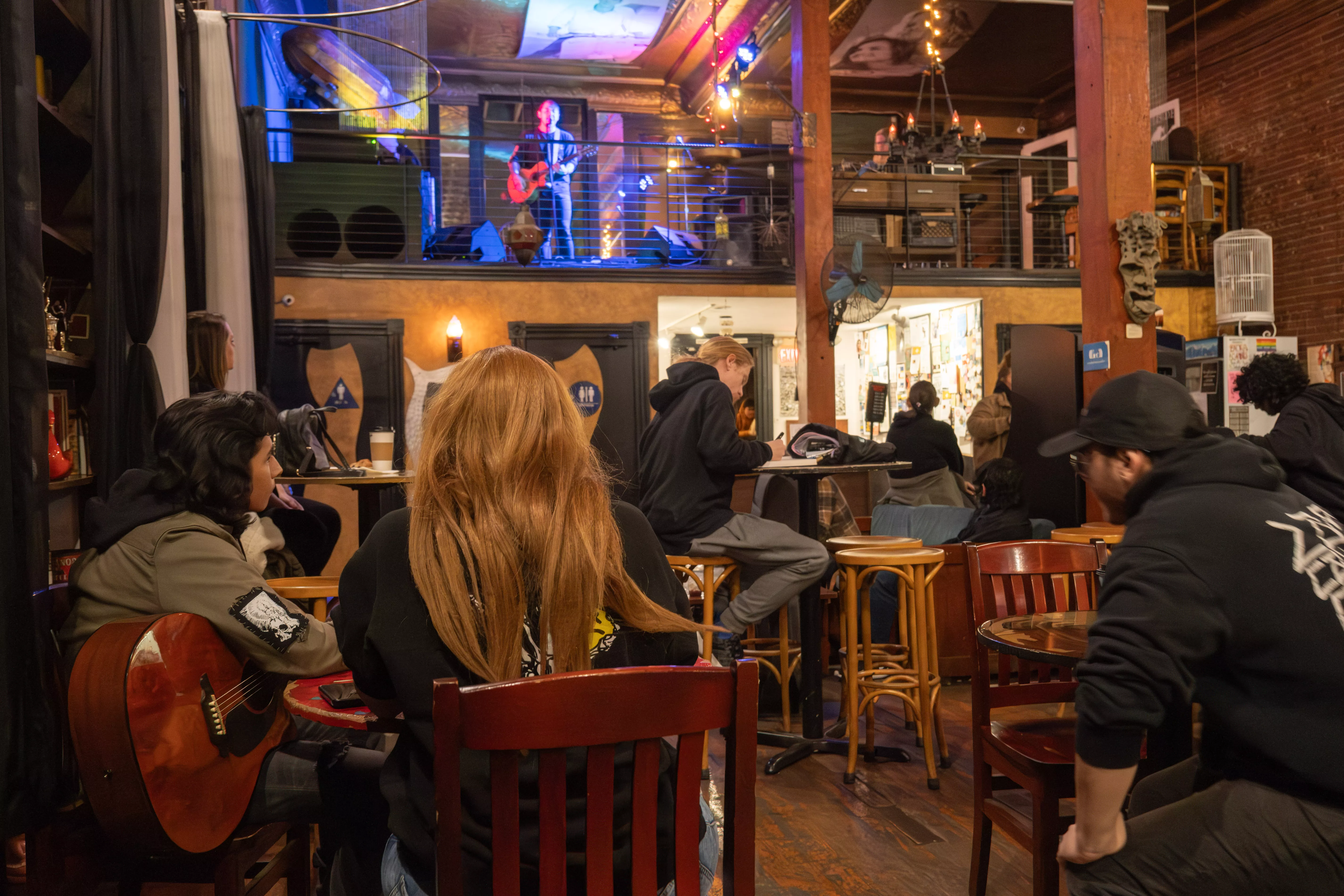 Audience watches performer sing at back to the grinds open mic music night