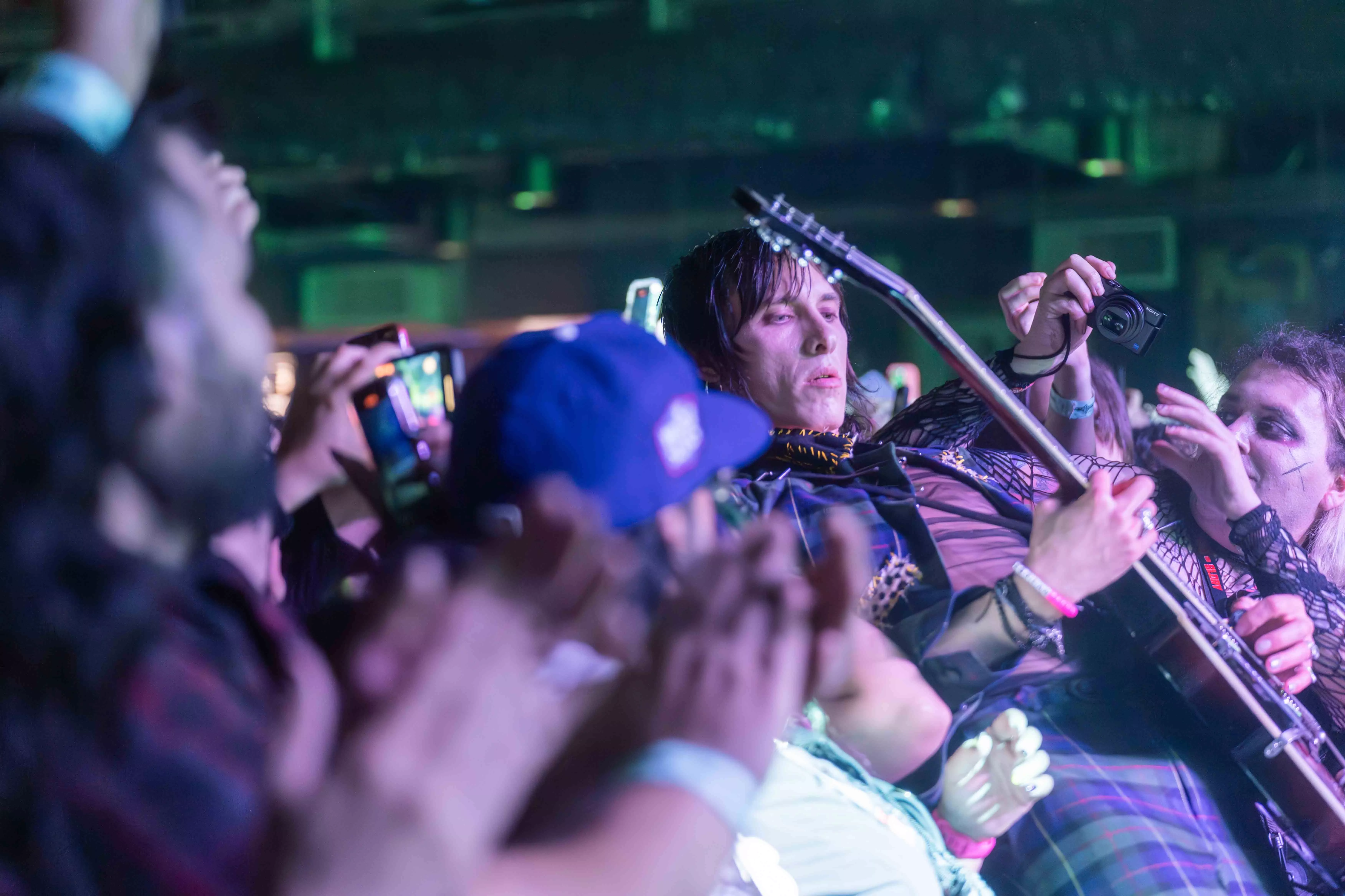 A guitarist leans into a crowd of fans while playing the guitar at the House of Blues