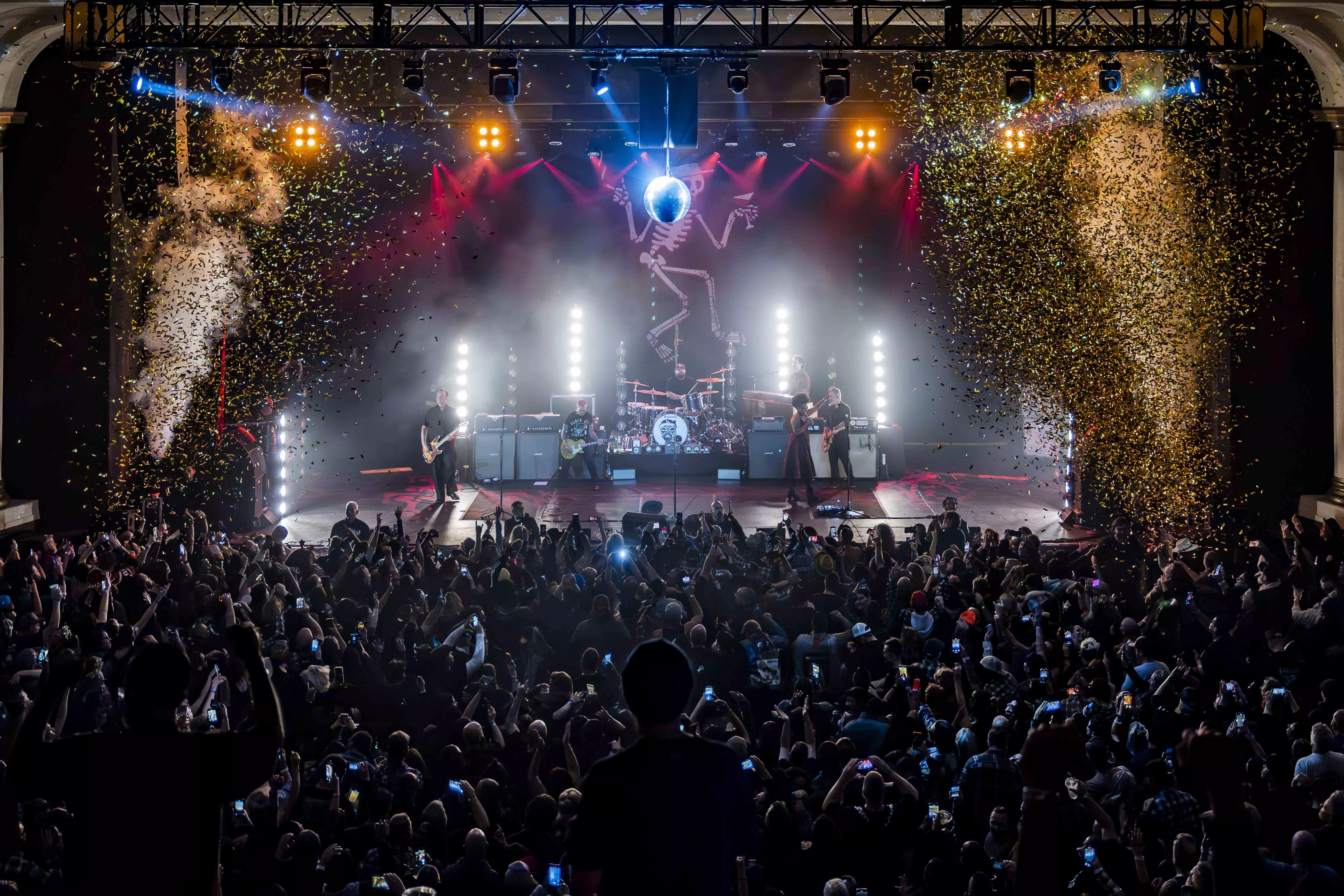 Stage performance with crowded auditorium and confetti cannons going off