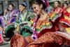 A female presenting person wearing a colorful folklorico skirt dances down the parade route at Palm Springs Pride on Nov 4 in Palm Springs