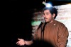 A comedian on stage speaks into a microphone