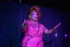 a drag queen in a dress performs on stage