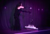 A drag queen performs on stage with a model Titanic