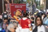 A crowd of people swarm the streets around a sign that reads Happy Year of the Dragon