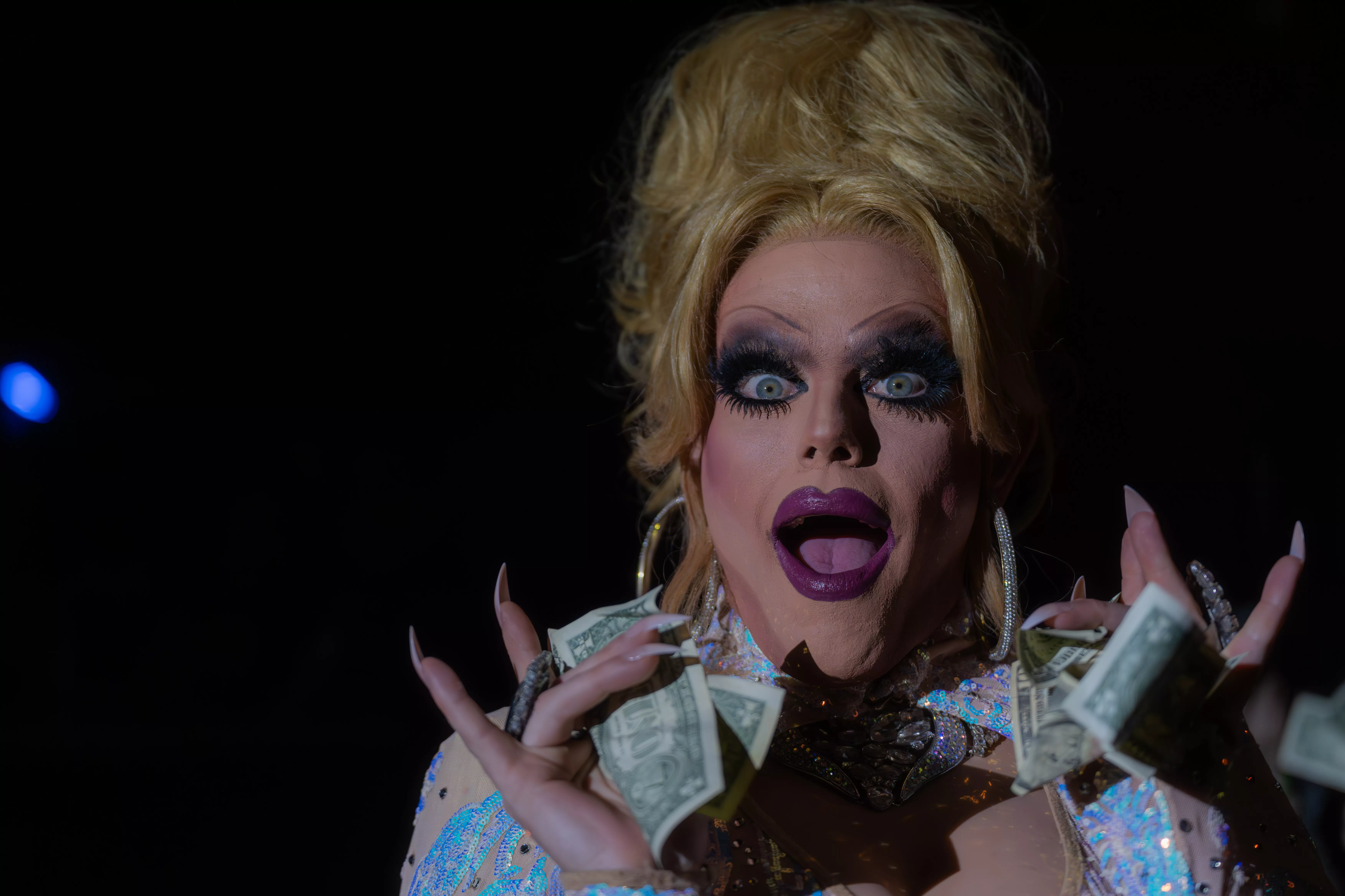 A female presenting performer against a black back drop