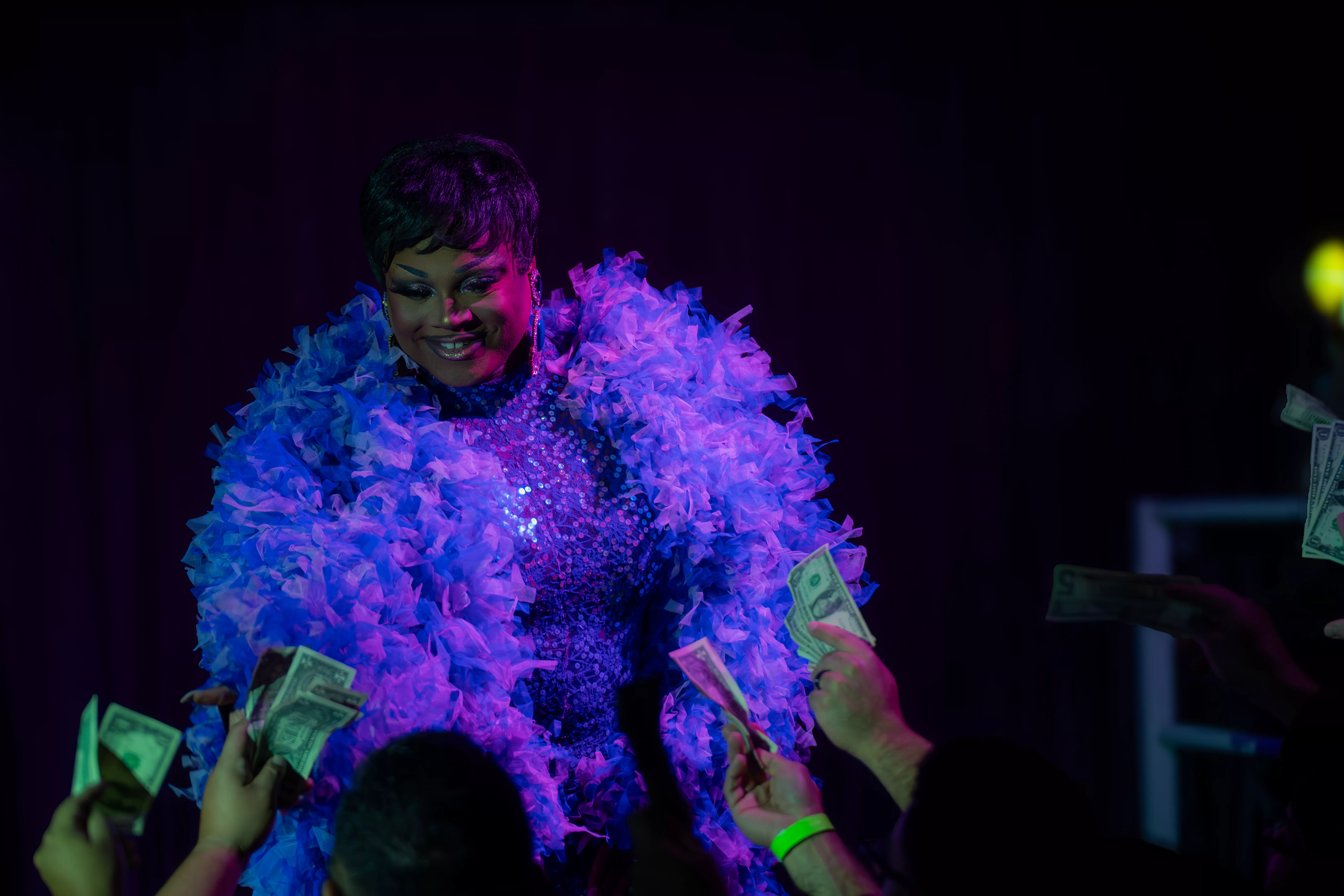 A female presenting performer against a black back drop