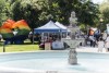A fountain with a pride festival in the background