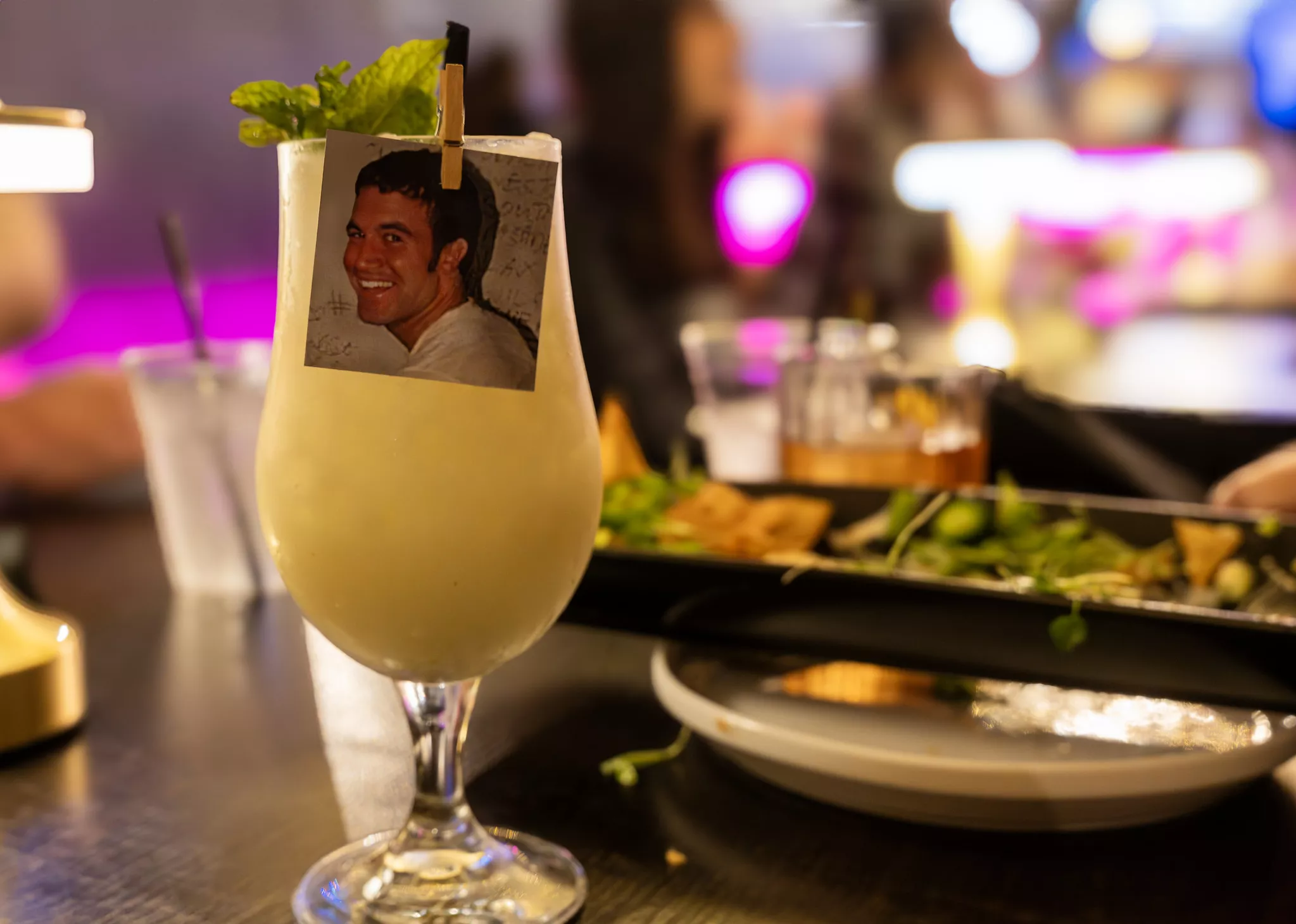 A mocktail with a picture of Tom from MySpace clipped to the glass