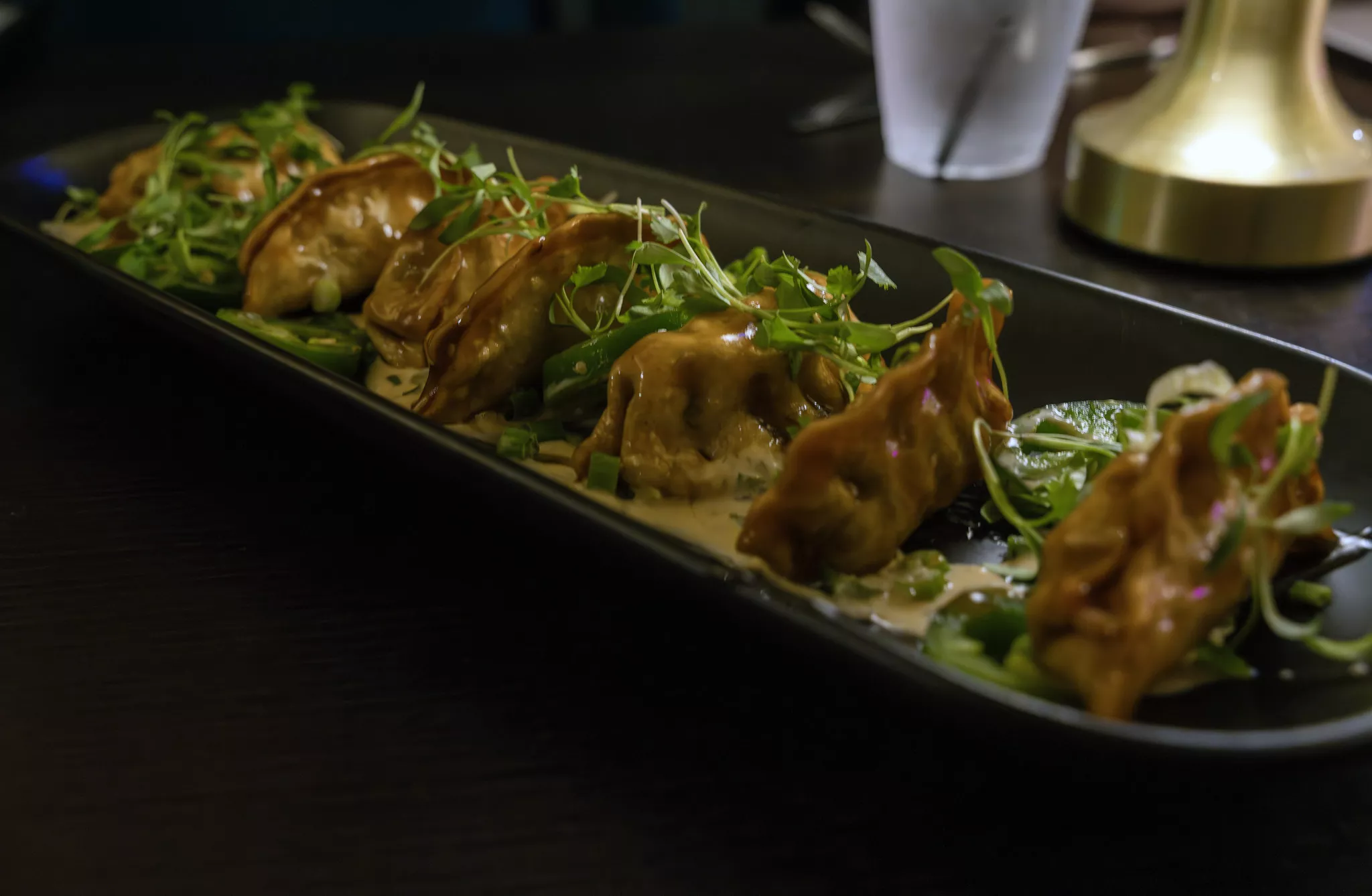 a plate of pot stickers garnished with green onion