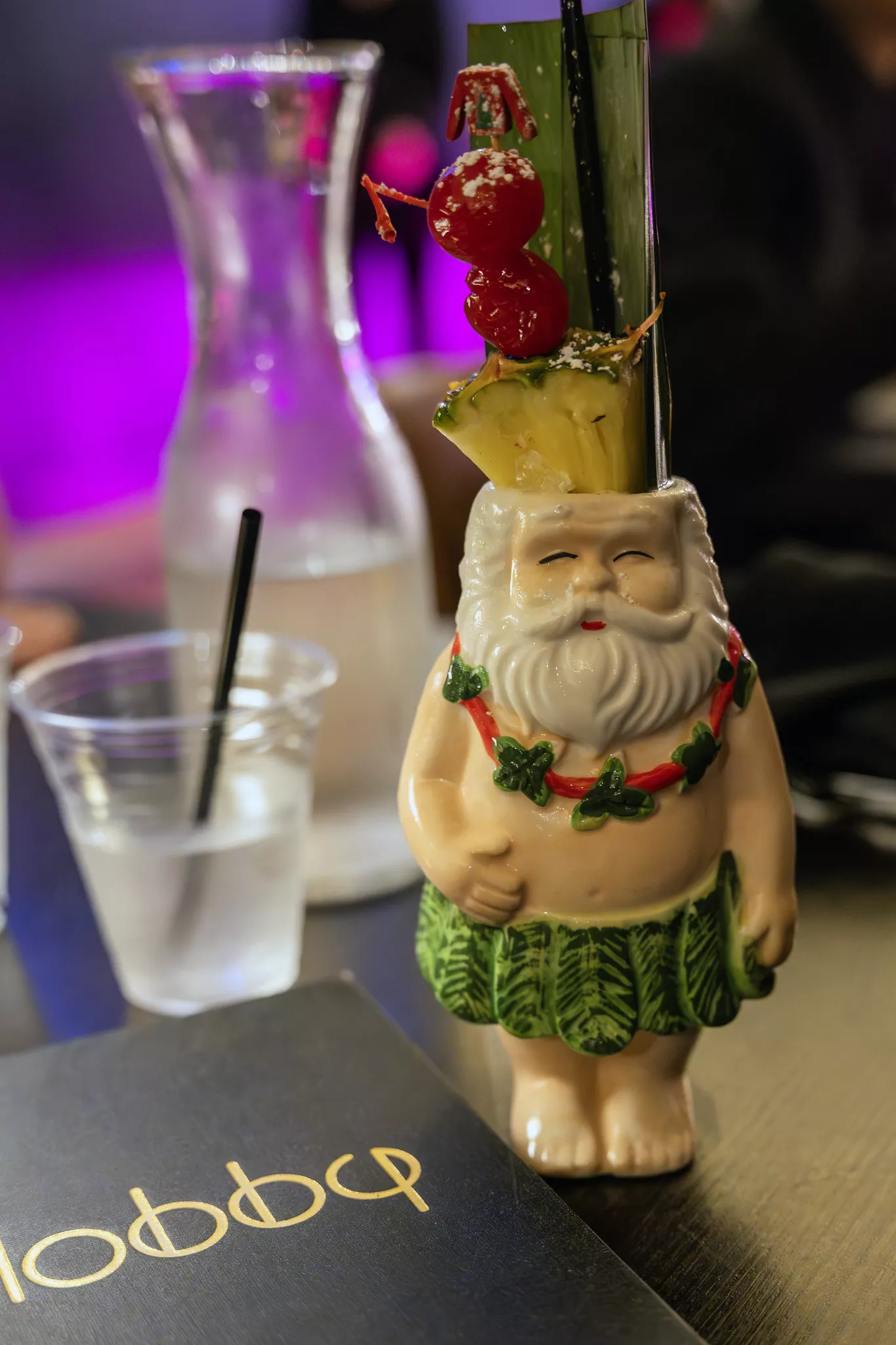 A mug decorated like Santa Clause wearing only a grass skirt and a lei