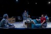 A group of actors sit on furniture on the set of the play Laughter on the 23rd Floor